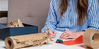 Femme emballant un cadeau avec le film de protection Scotch™ Cushion Lock™
