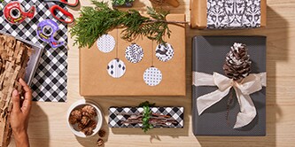 Création de décorations de cadeaux à partir d'éléments naturels et verts tels que des pommes de pin ou du houx
